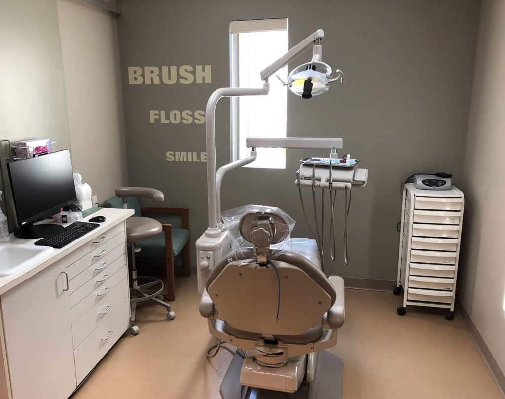 An exam room with a dental exam chair in the middle